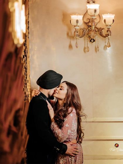A romantic kiss in a beautifully lit hallway. We use the venue's ambiance to create intimate and stylish portraits away from the main party.