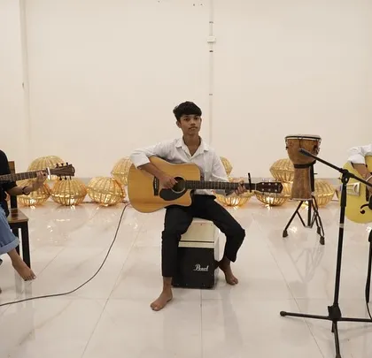 A trio of our talented guitar students, fully focused during their performance. Our showcases provide a platform for students to demonstrate their instrumental skills in a professional setup.
