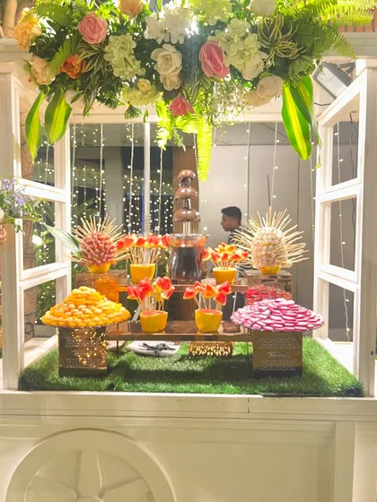 A close-up of the dessert cart, showing the chocolate fountain surrounded by fruit skewers and other treats.