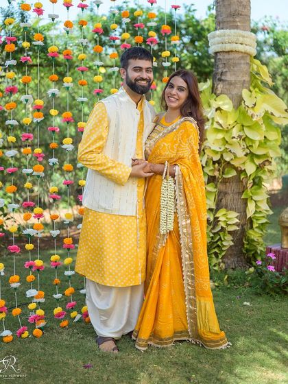A beautiful portrait of the couple during their Haldi ceremony in Goa. The vibrant marigold backdrop adds a traditional and colorful touch to this happy moment.