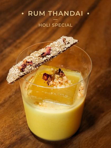 Our Holi Special, the Rum Thandai. We give the traditional festive drink a spirited twist with rum and top it with a house-made Thandai Masala Chikki.