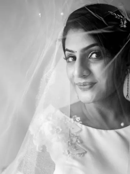 Another take on the "through the veil" shot, this black and white bridal portrait captures the bride looking directly at the camera with a gentle smile. The veil adds a layer of softness and romance.