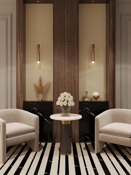 We create elegant seating nooks perfect for quiet moments. This corner features two plush armchairs, a marble side table, and a backdrop of wood and black marble paneling with delicate pendant lights for focused illumination.