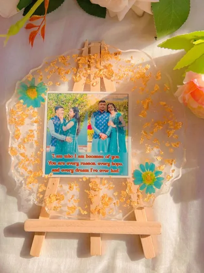 Simplicity can be so powerful. This clear resin platter is decorated with just a sprinkle of gold leaf and a few pressed flowers, keeping the focus on the couple's photos and the lovely quote.