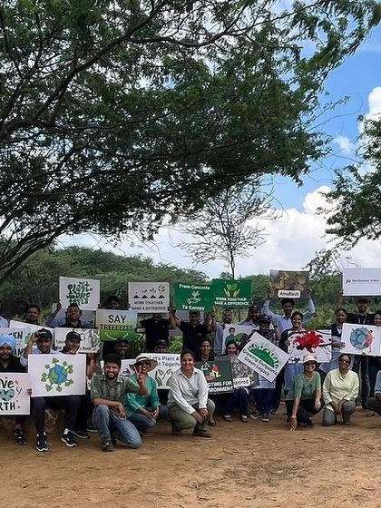 The Padmini VNA team poses with signs after planting 1000 native Aravali species, celebrating their contribution to a greener future.