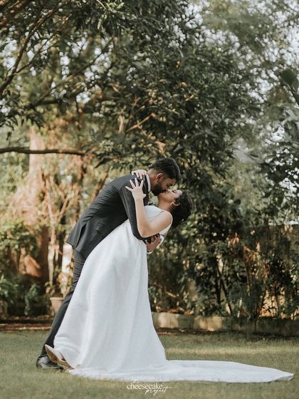 The classic dip and kiss! A romantic and timeless shot from a beautiful Christian wedding in a lush garden.