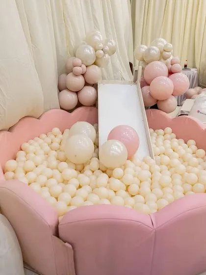 A close-up of the custom-designed, flower-shaped ball pit, filled with white and pink balls to match the party's pastel palette.
