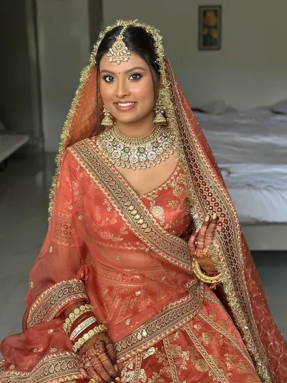 A full portrait of the bride, looking confident and beautiful. This is a testament to how stunning makeup can be when it celebrates brown skin.