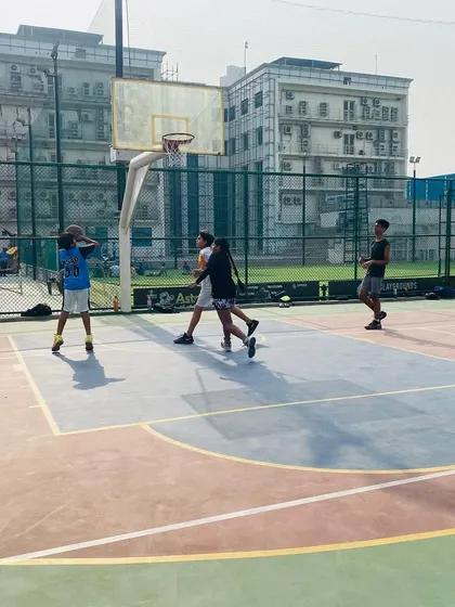 A young female player learns to shoot, focusing on proper form.