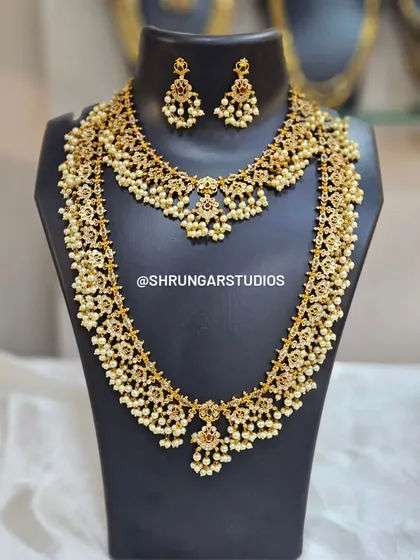 A beautiful bridal combo set with a necklace and matching long haar, both featuring intricate floral motifs and pearl drops.