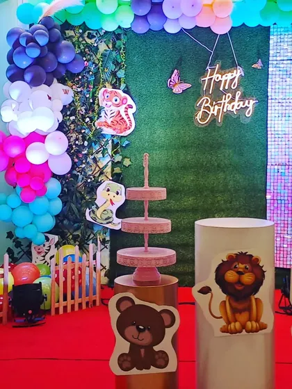 A detailed view of the left side of the woodland party setup, focusing on the colorful balloon clusters and the charming animal cutouts.