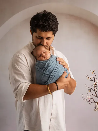 A father's promise, captured in a single frame. He holds his newborn son close, a quiet and powerful portrait of protection and love.
