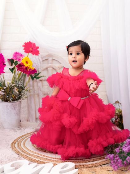 One and absolutely fabulous. This little princess in her stunning red tulle dress is ready to celebrate her first birthday in style.