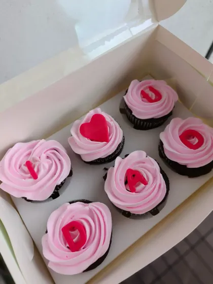 A box of "I ❤️ DAD" cupcakes for Father's Day. Each pink-frosted cupcake has a letter to spell out the sweet message.