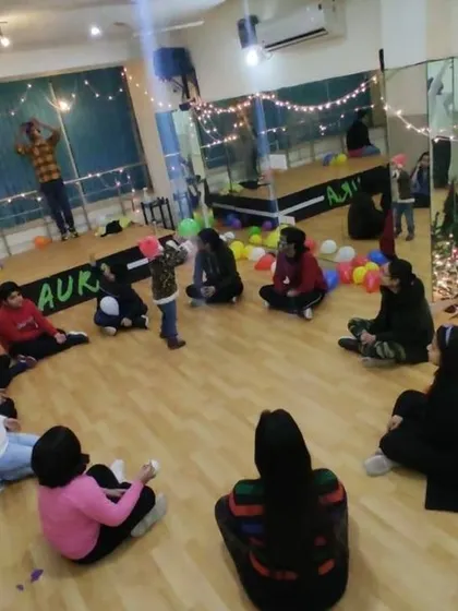 A wide view of a New Year's get-together, with guests seated in a circle for a party game. This shows how the large floor area can be used for interactive group activities during events.