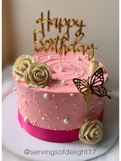 A lovely pink birthday cake with white chocolate roses and a delicate butterfly. The pearl details add a classic, elegant touch.