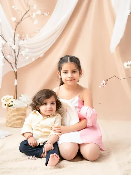 A sweet portrait of a big sister with her little brother. This photo captures the gentle and protective bond between siblings, a precious memory for the whole family.