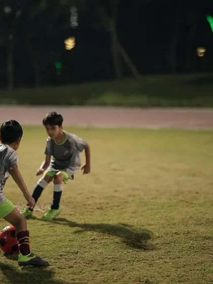 Focus. A young player dribbling during a night session. We create a focused environment where every player can concentrate on improving their technique.