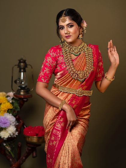A full-length view of the stunning bridal attire. The layered necklaces, vaddanam, and maang tikka come together to create a complete and regal look.