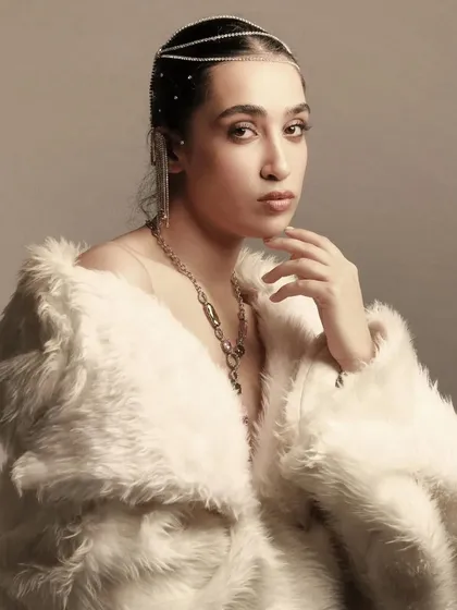 An ethereal look featuring a white fur coat and a delicate, jeweled headpiece. The makeup is soft and luminous, creating an almost angelic, high-fashion feel.