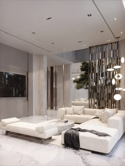 A wide shot of the living area, showcasing the large sectional sofa, reflective partition, and sculptural lighting. The indoor tree adds a strong natural element.