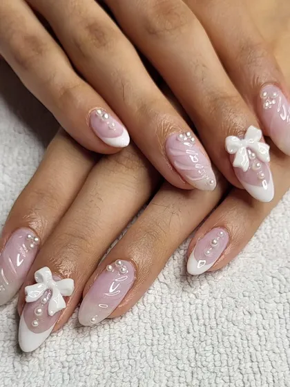 I love bringing Korean nail trends to my studio. This set features a soft pink base with a marble effect, delicate French tips, and is adorned with hand-sculpted 3D bows and pearls for a look that is both sweet and incredibly chic.