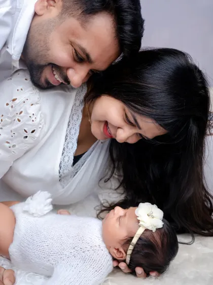 A tiny miracle, wrapped in love and dreams. This close up shot shows parents adoring their newborn, a perfect memory of when their family grew.