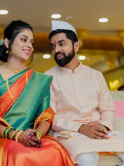 A candid moment of the couple seated during their engagement ceremony, sharing a quiet conversation.