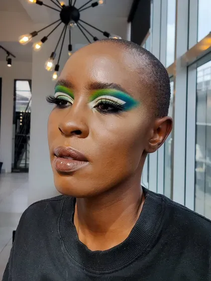 Another view of the creative green and blue eye makeup, showing the blend of colors and the sharp wing.