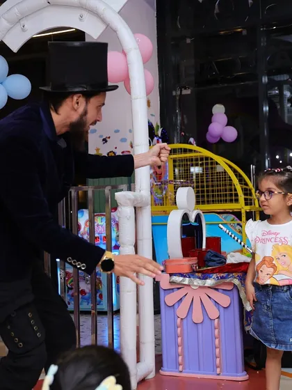 Another moment from the magic show, where a young guest is mesmerized by a classic trick.