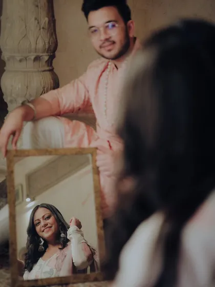 A very creative and intimate portrait using a small mirror. This unique composition focuses on the bride's reflection, as seen by the groom.