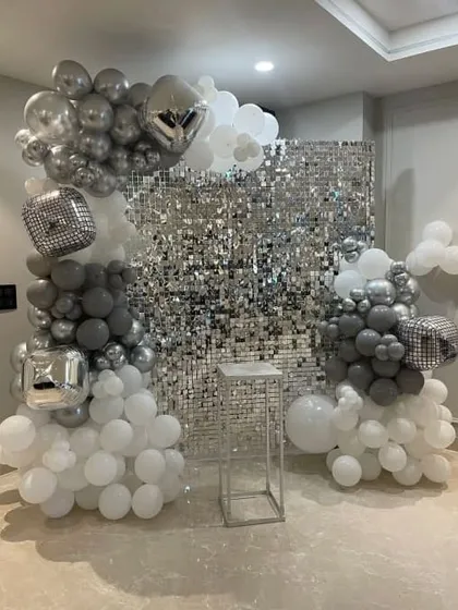This shimmering silver sequin wall is one of my most requested backdrops for parties and events. Here, I've framed it with an organic balloon garland using white, grey, and metallic silver balloons, creating a glamorous photo booth area.