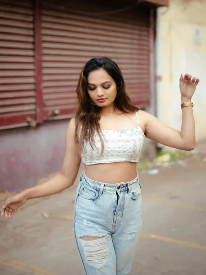 A candid-style street portrait. The model's natural movement and the gritty urban background create an authentic and relatable fashion shot.