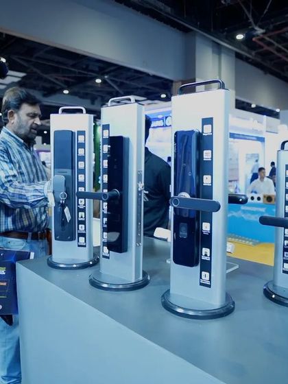 Visitors at the Smart Home Expo examining my diverse range of smart door locks. My display was designed to allow a hands-on experience with the different models and their features.