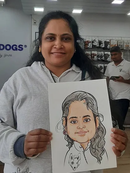 A smiling guest holding her finished portrait, which includes a charming sketch of her dog.