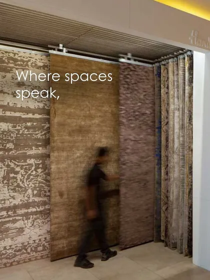A dynamic display system at the Hands Carpets showroom, allowing customers to easily slide and view large carpet samples. This functional design element enhances the interactive and tactile nature of the retail experience.