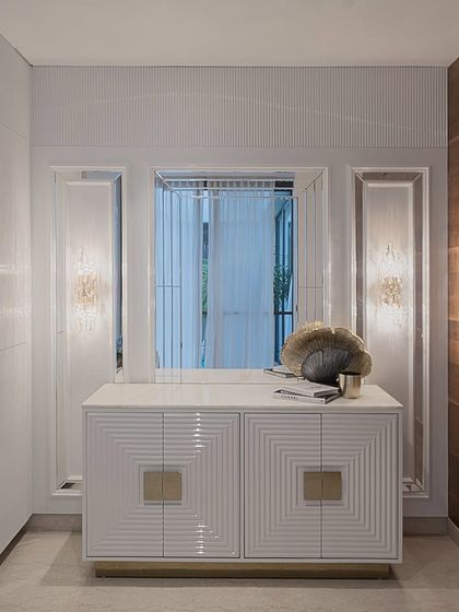 A custom-designed credenza featuring a geometric, fluted pattern on the doors with statement brass hardware. The piece is both a functional storage unit and a work of art, showcasing our expertise in bespoke furniture.