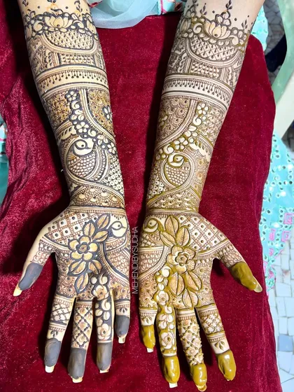 The same beautiful design against a red background, highlighting the two-tone effect of the fresh and drying henna paste.