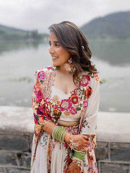 A close-up of the bride's Haldi look. The floral embroidery on her blouse and the fresh flowers in her hair create a beautiful, cohesive aesthetic.