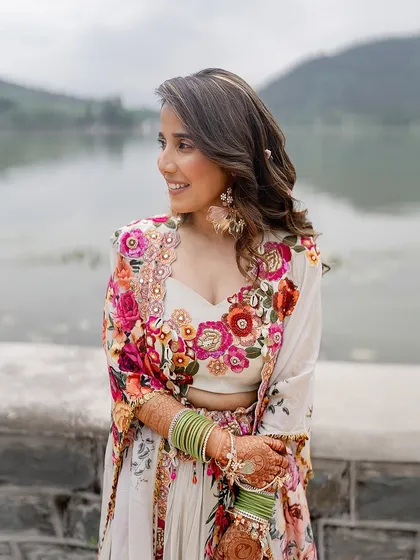 A close-up of the bride's Haldi look. The vibrant floral embroidery on her outfit is a beautiful celebration of color and craftsmanship.