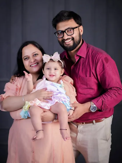 A bright and cheerful family portrait. The parents' loving gaze on their smiling daughter is what makes this photo so special.