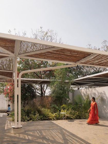 (Duplicate of 50) A woman in a colourful sari walks through the shaded courtyard, highlighting the school's role as a center for the entire community.