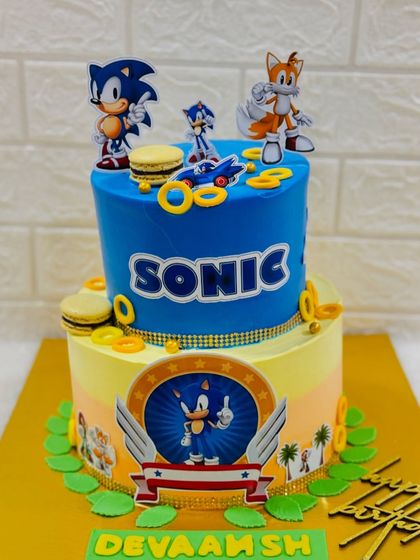 Gotta go fast! A Sonic the Hedgehog cake for a young gamer's birthday, featuring two tiers of fun with Sonic, Tails, and golden rings made from macarons.