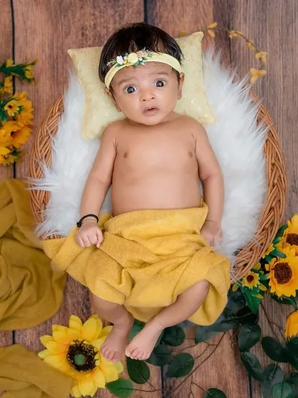Capturing those bright, curious eyes is a special part of a baby milestone session. This little one is surrounded by cheerful sunflowers, creating a vibrant and joyful portrait that perfectly matches her sunny disposition.
