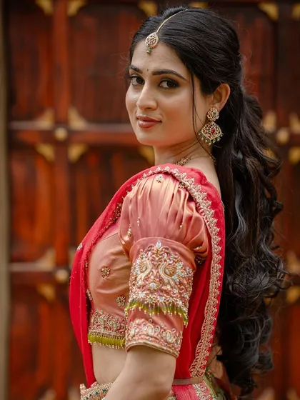 A close-up of Moksha's beautiful half-ponytail hairstyle and soft, glowing makeup.