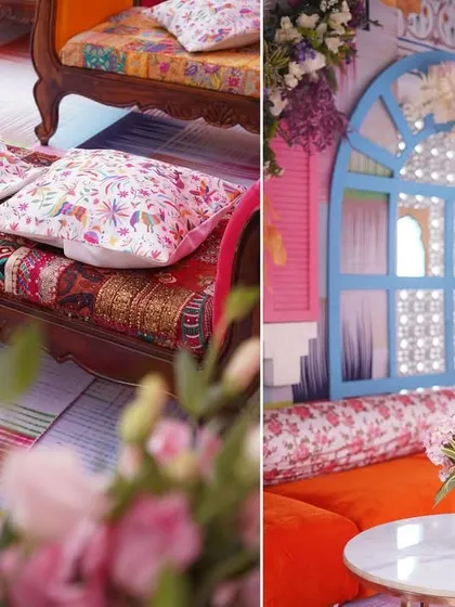 A close-up of the eclectic furniture used at the Haldi, showing a mix of patterned fabrics and colorful cushions. In the background, a decorated window panel adds to the festive, carnival-like atmosphere.