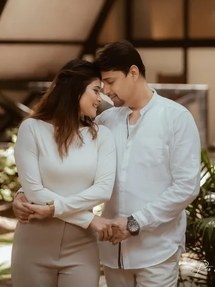 A tender moment between a couple, their foreheads touching as they hold hands. This portrait from their pre-wedding shoot highlights their deep connection.