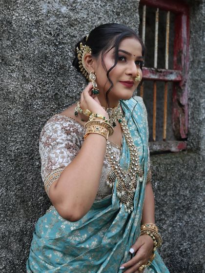 A close-up of the blue Nauvari look, highlighting the kundan jewellery and traditional ear cuff.