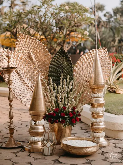 Another traditional decor vignette, featuring a brass lamp (diya) and floral arrangements.