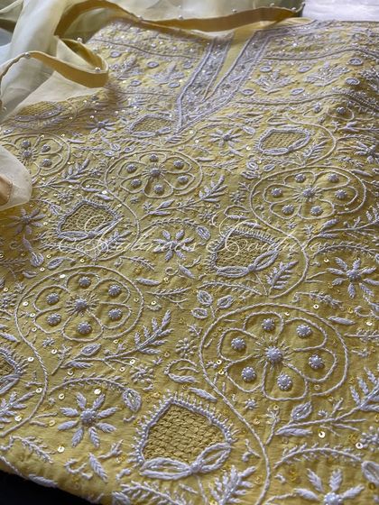 A macro view of the embroidery, where the fine Chikankari stitches and sequin work are clearly visible.